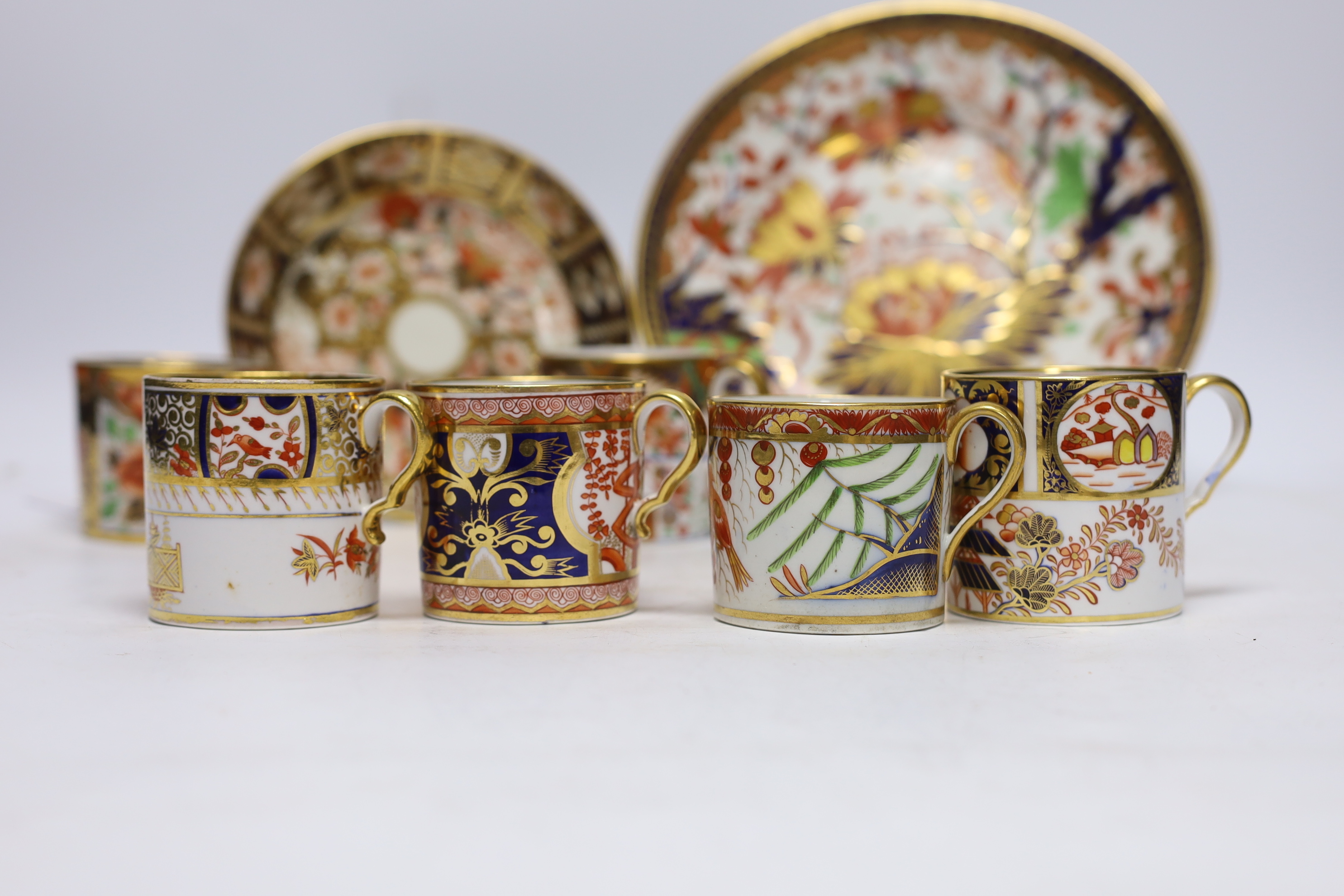 Ten 1800-1820 English porcelain coffee cans, including Imari pattern examples, one with matching saucer, together with a side plate (12)